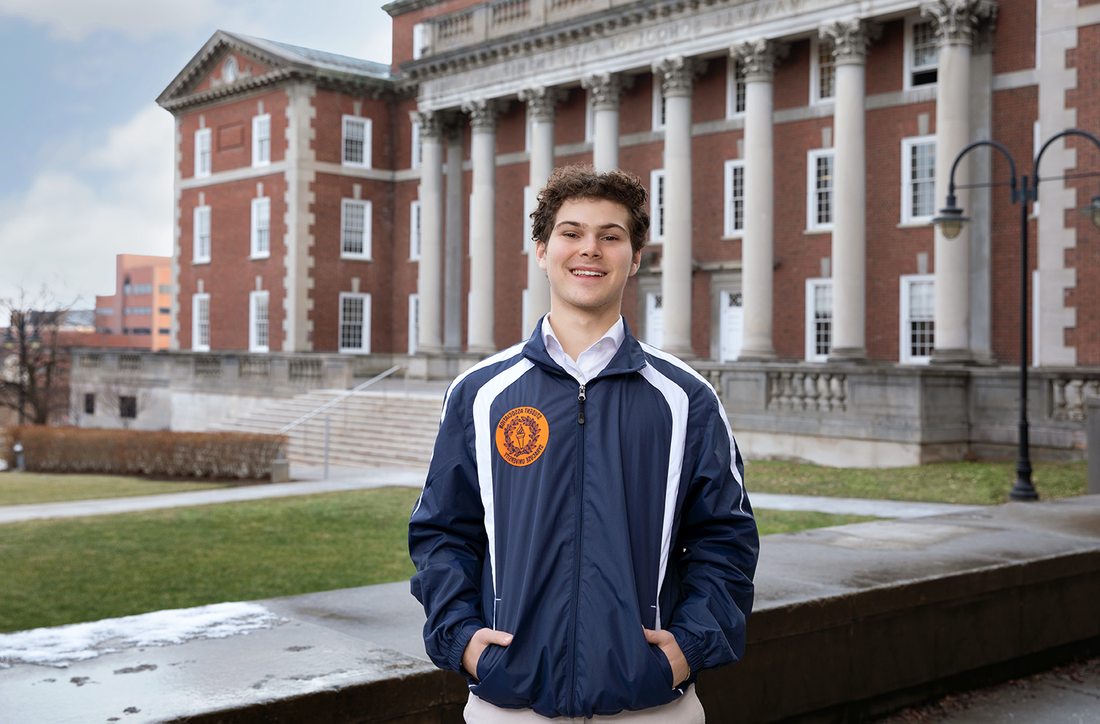 Aden Solomon standing outside of the Maxwell School.